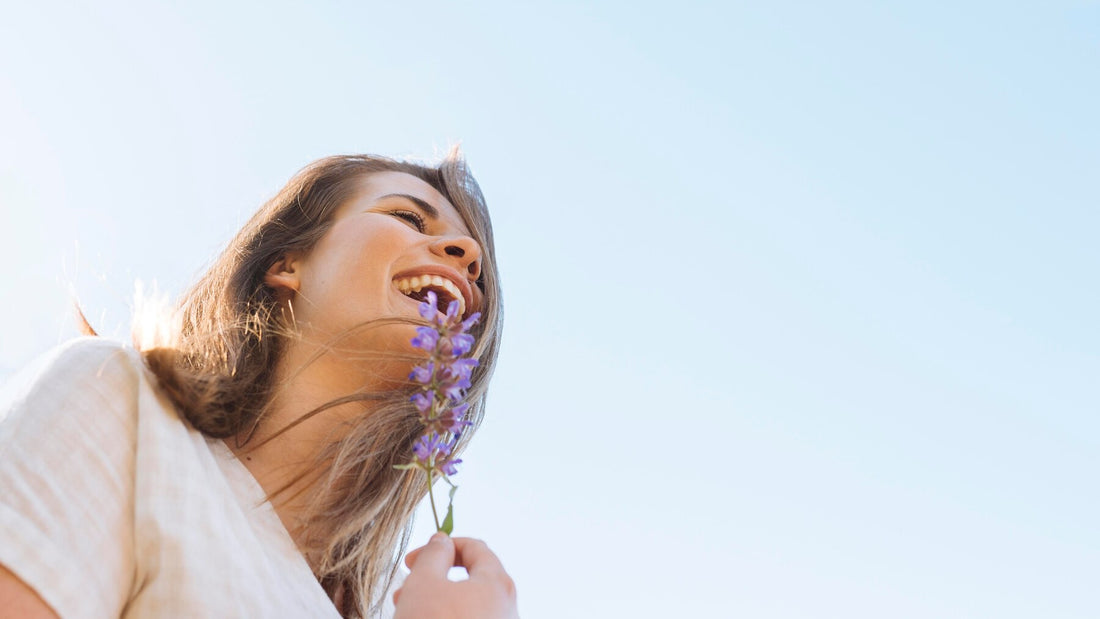 mulher com expressão feliz segurando ramo de lavanda