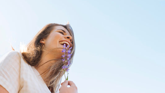 mulher com expressão feliz segurando ramo de lavanda